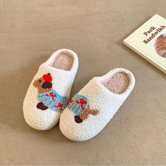 A pair of white fuzzy memory foam house shoes featuring a cute dachshund with blue stripes and red bows, offering a soft and cozy cotton feel.