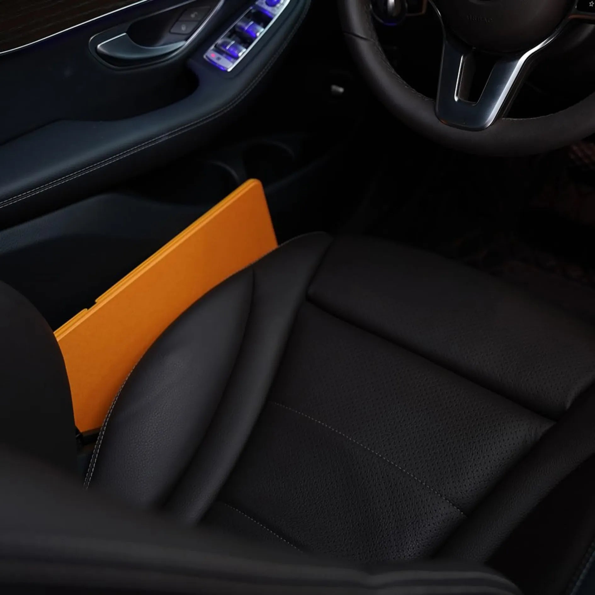 The foldable lap desk is shown fully collapsed and stored between a car seat and door. Its ultra-thin design makes it nearly invisible and perfect for on-the-go storage.