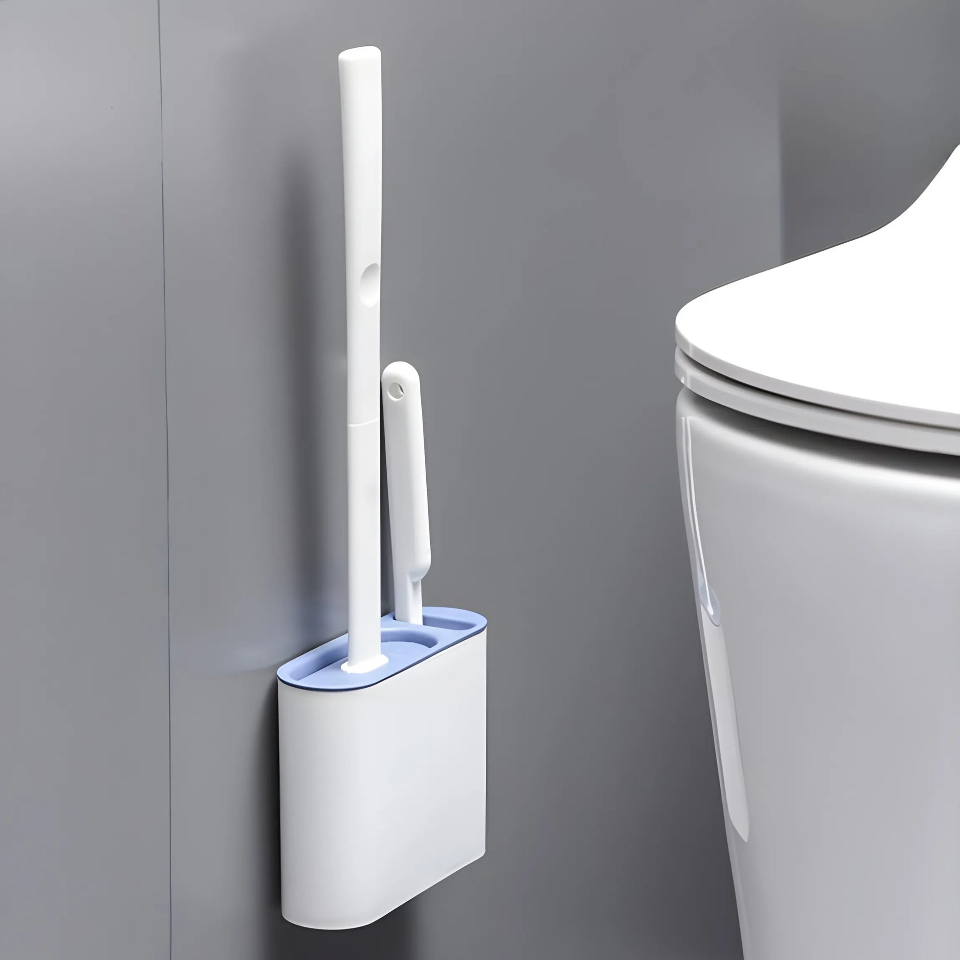 Silicone toilet brush mounted on the wall beside a toilet, showcasing its space-saving minimalist design that can be placed on the floor or adhered to the wall.