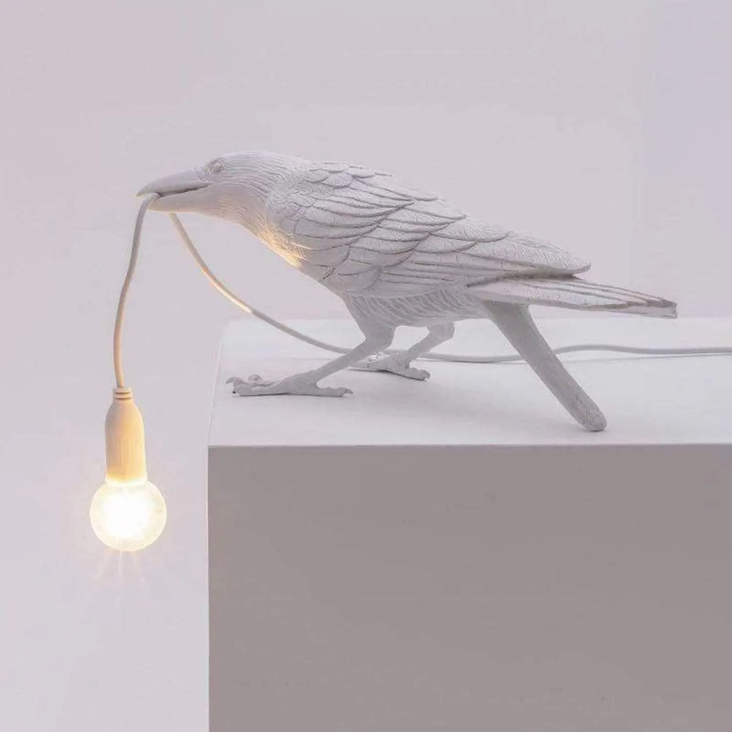 White bird-shaped lamp with a bulb on a white background