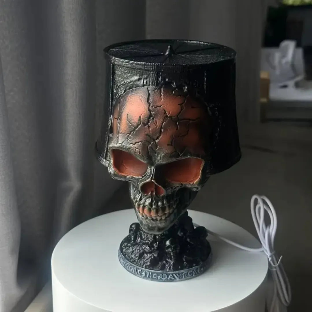 Halloween skull lava lamp with cracked texture and red glow, placed on a white table with black tattered shade.