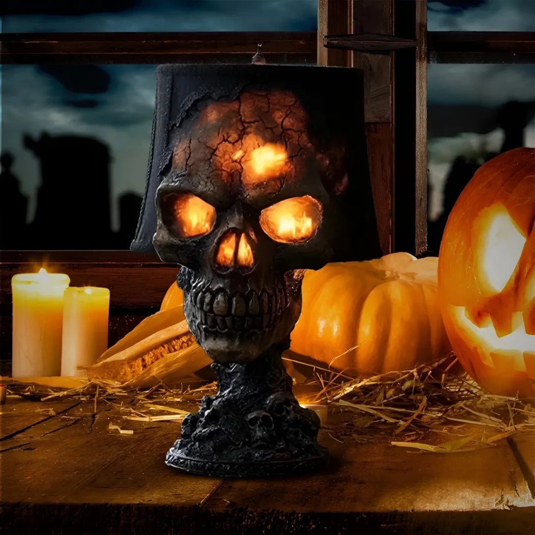 Decorative skull with glowing eyes on a rustic wooden table with pumpkins and candles.