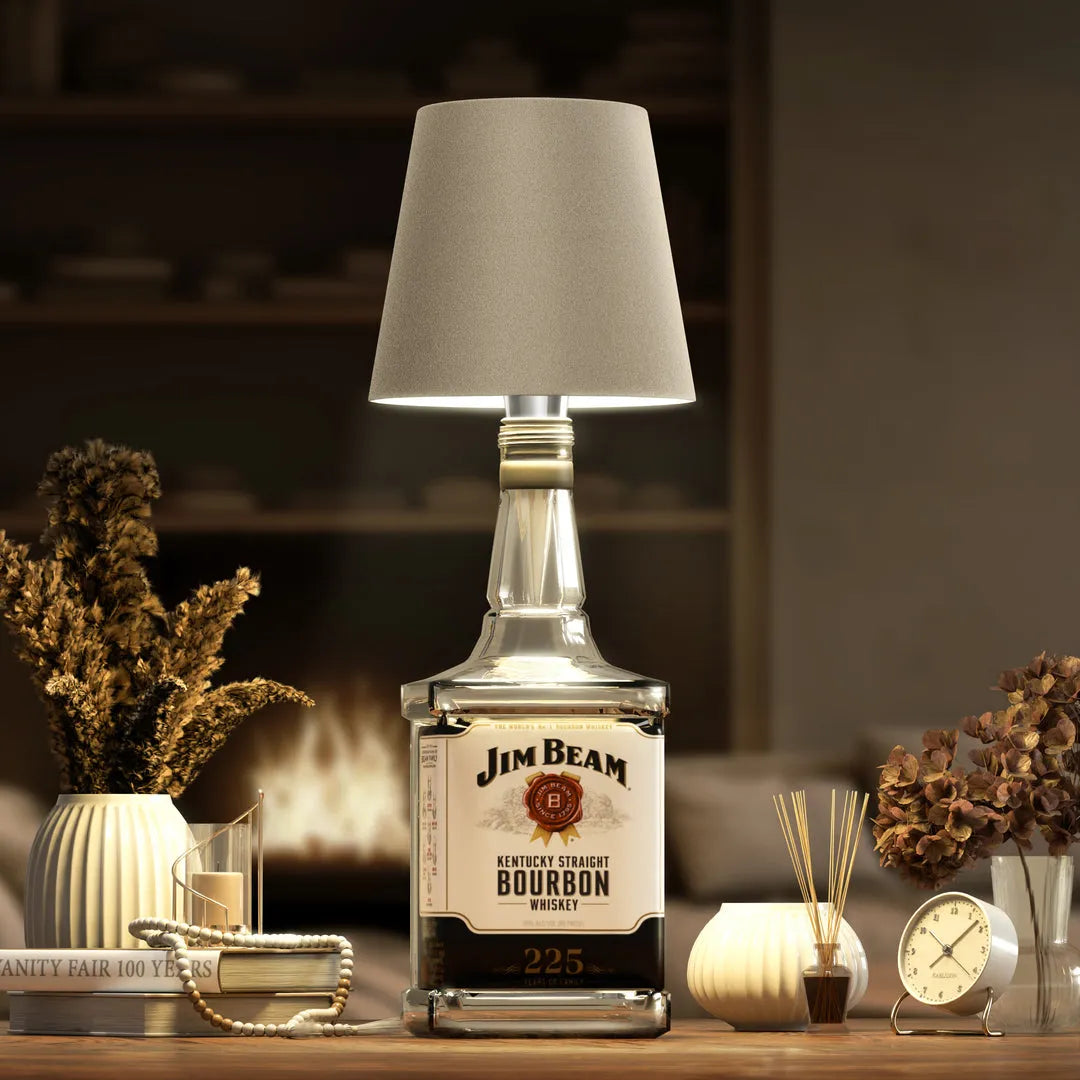 Jim Beam bourbon bottle repurposed as a lamp with decorative items on a table.
