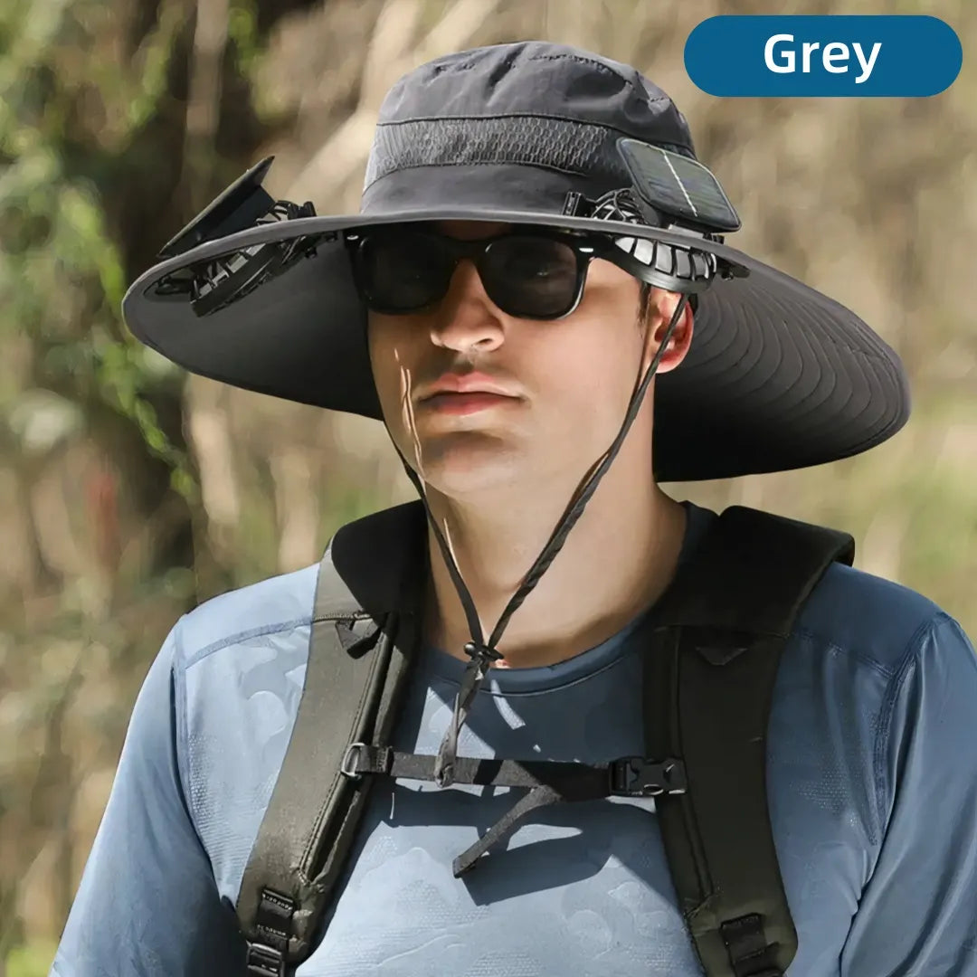 Person wearing a large gray sun hat with a solar panel, sunglasses, and a backpack in a forest setting.