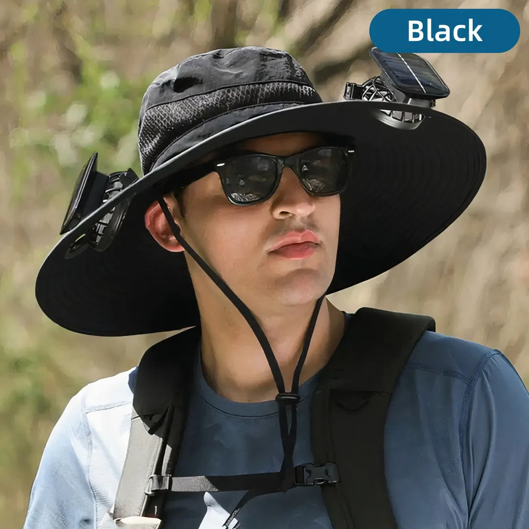 Person wearing a black wide-brimmed hat with a solar panel attachment, outdoors.