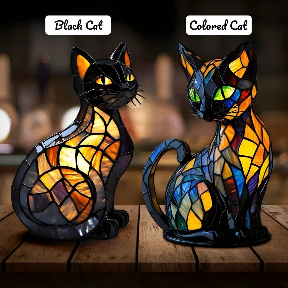 Two stained glass cat lamps, one black and one colored, on a wooden surface with a blurred background.