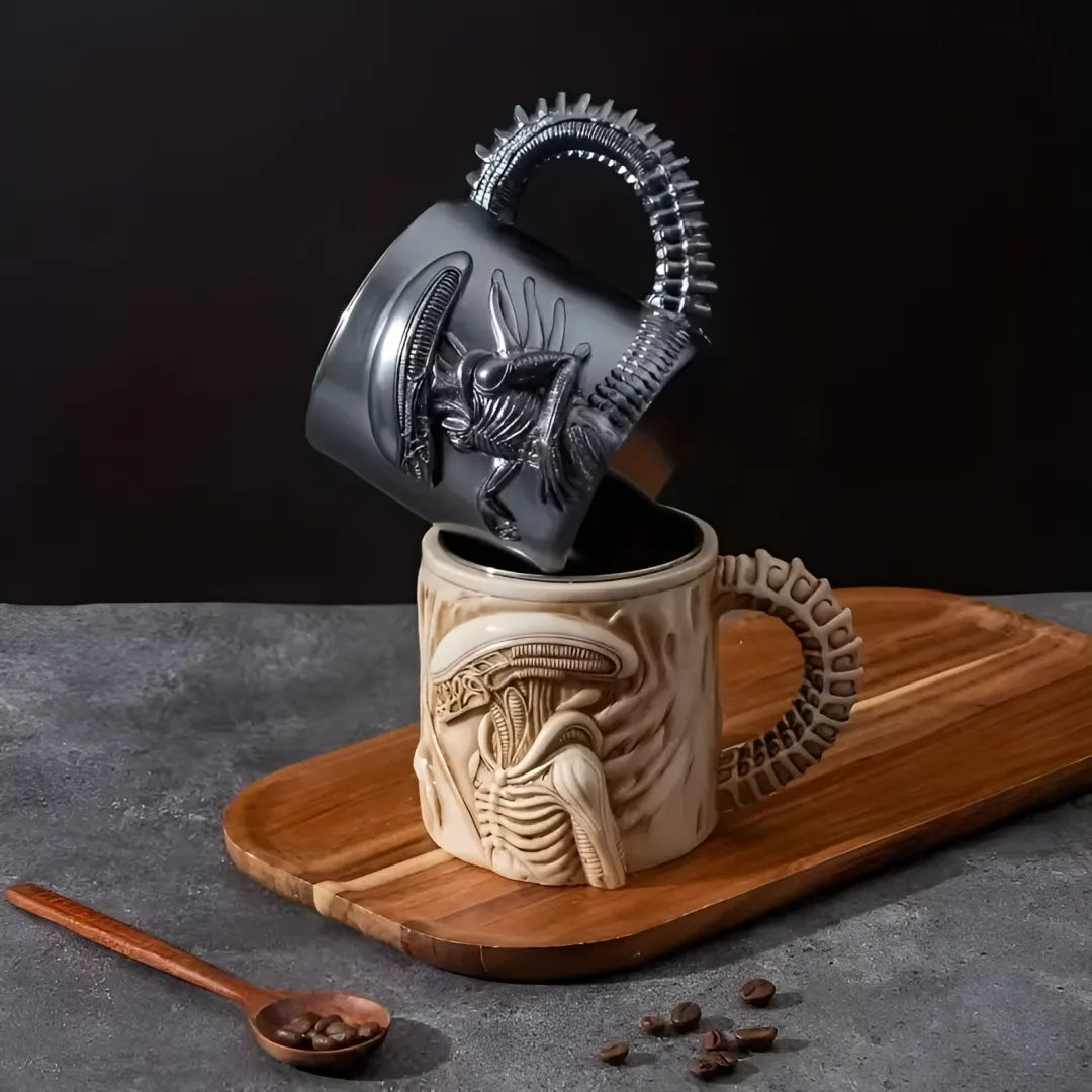 Mug with alien design on a wooden board with coffee beans and a spoon.