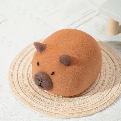 Brown capybara-shaped PU sponge with round body, dark ears and nose on woven mat