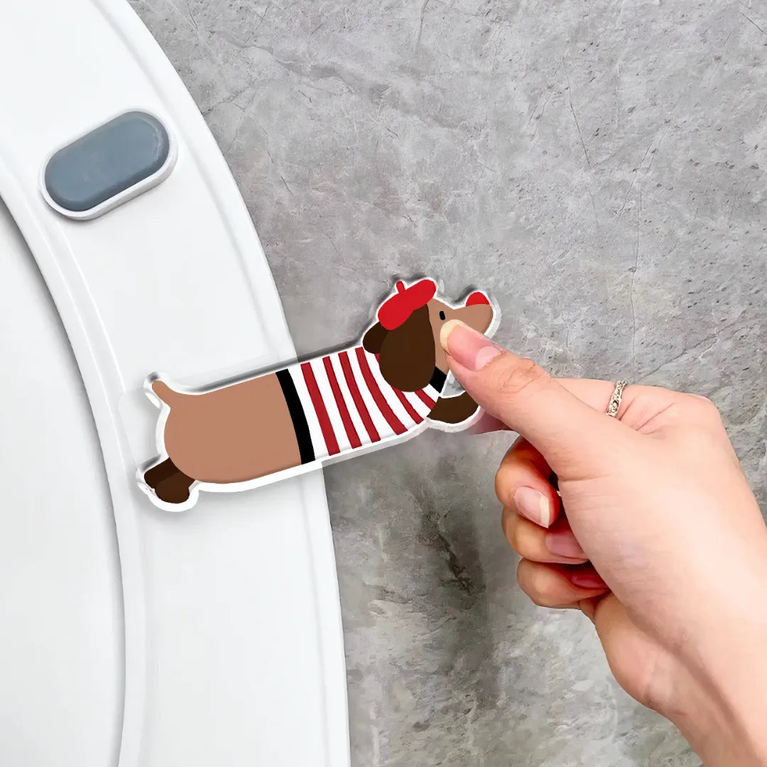 Hand installing a red striped dachshund-shaped toilet seat lifter onto a white toilet lid, showing easy and simple installation process.