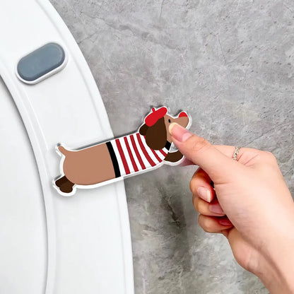 Hand installing a red striped dachshund-shaped toilet seat lifter onto a white toilet lid, showing easy and simple installation process.