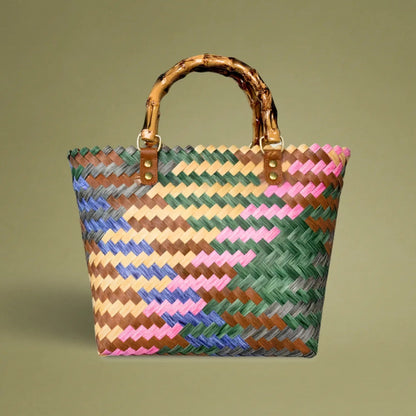 Handwoven bamboo tote with colorful diagonal striped pattern, crafted with care from recycled plastic, featuring a vintage, artisanal look.
