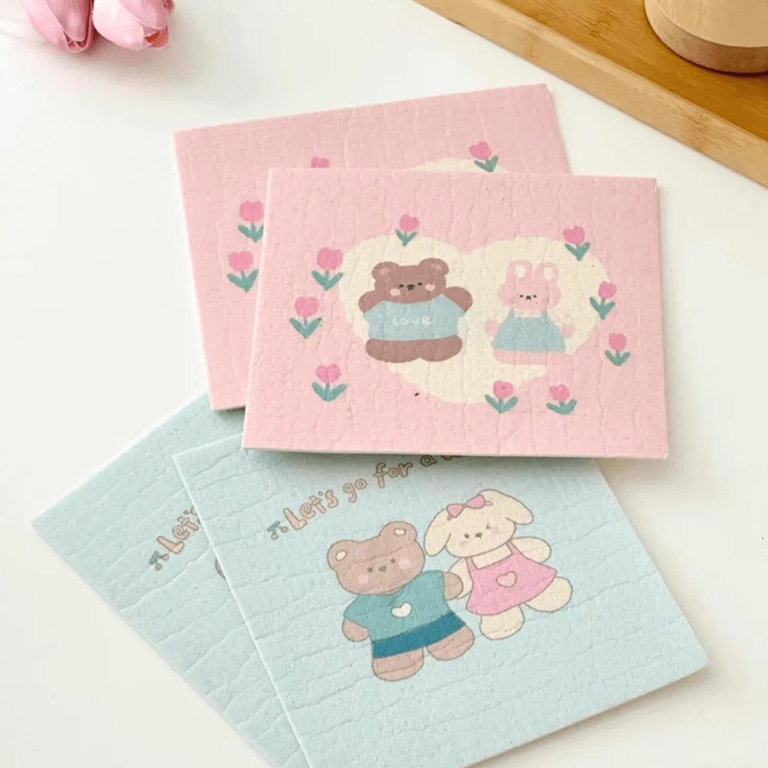 Set of four pink and blue bear-print cellulose towels stacked neatly.