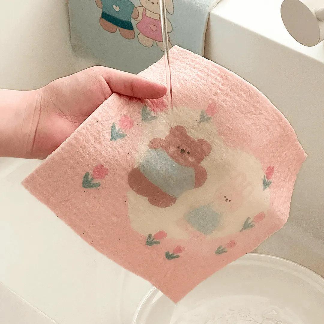 Bear-print cellulose towel expanding and softening under running water.