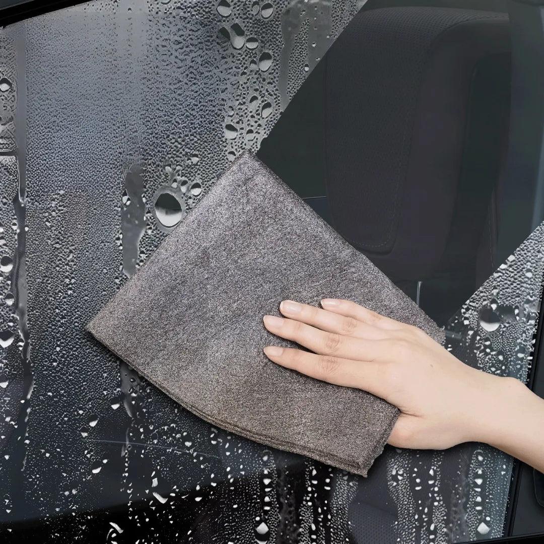 Microfiber cloth wiping a glass covered in water droplets, instantly leaving a clean, streak-free surface with minimal effort, demonstrating efficient and spotless cleaning performance.