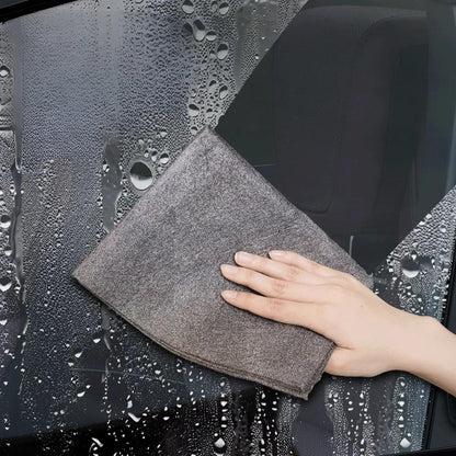 Microfiber cloth wiping a glass covered in water droplets, instantly leaving a clean, streak-free surface with minimal effort, demonstrating efficient and spotless cleaning performance.