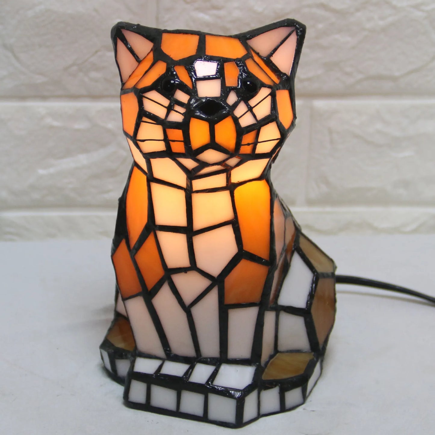 Mosaic cat-shaped lamp with warm colors on a white background