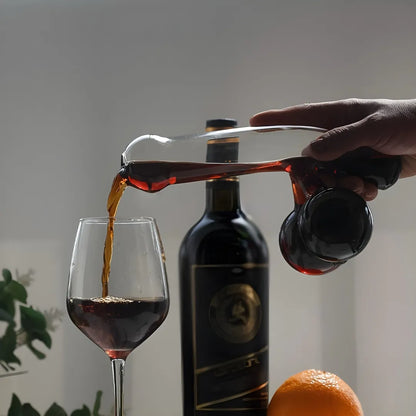 Person pouring dark liquid from a bottle into a glass with a blurred background