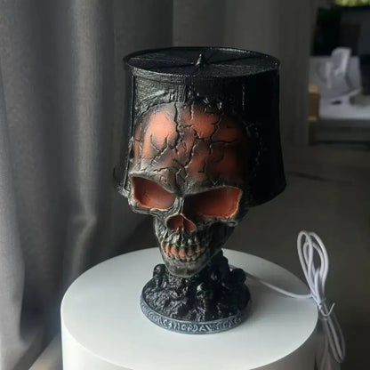 Halloween skull lava lamp with cracked texture and red glow, placed on a white table with black tattered shade.