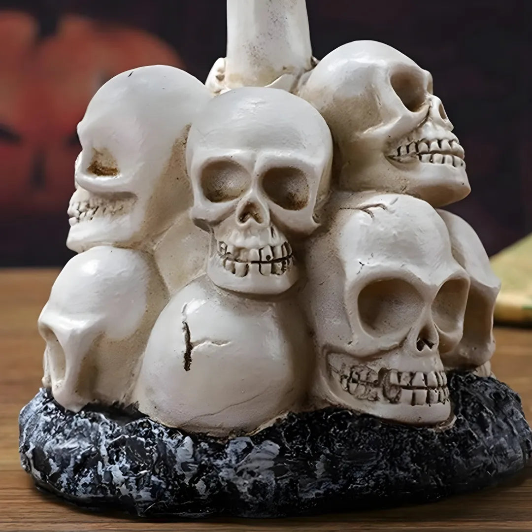 Close-up of Halloween solar garden lamp featuring intricately stacked white skulls with realistic cracks and textures, mounted on a rugged black stone base.