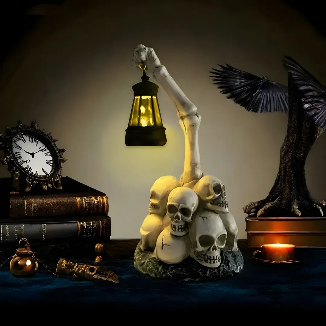 Halloween skull pile lamp with glowing lantern held by skeletal arm, surrounded by antique clock, books, and crow decor. Creates spooky atmosphere for Halloween displays.