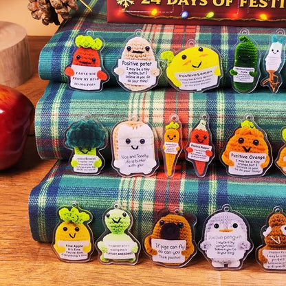 Handmade crochet potato ornament holding "I believe in you" sign from Emotional Support Advent Calendar 2025, displayed on festive plaid fabric