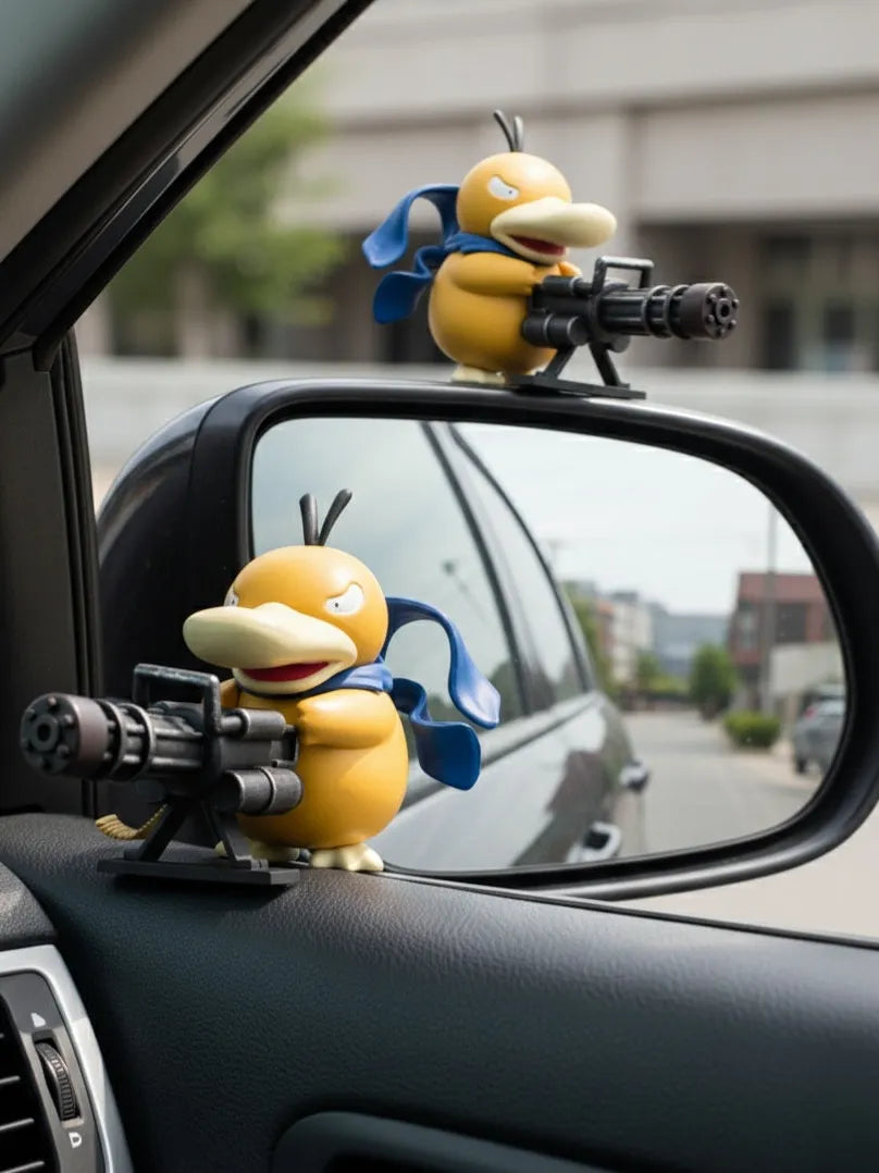 Chibi-style Psyduck car decor ornaments with machine guns and blue scarves mounted on side mirror and door panel against blurred street scene.