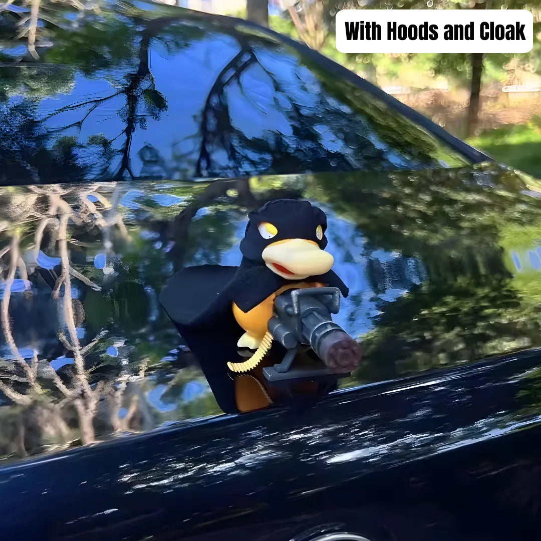 Psyduck car ornament with hooded cloak design holds toy gun mounted on glossy black car against sunny outdoor backdrop with trees.