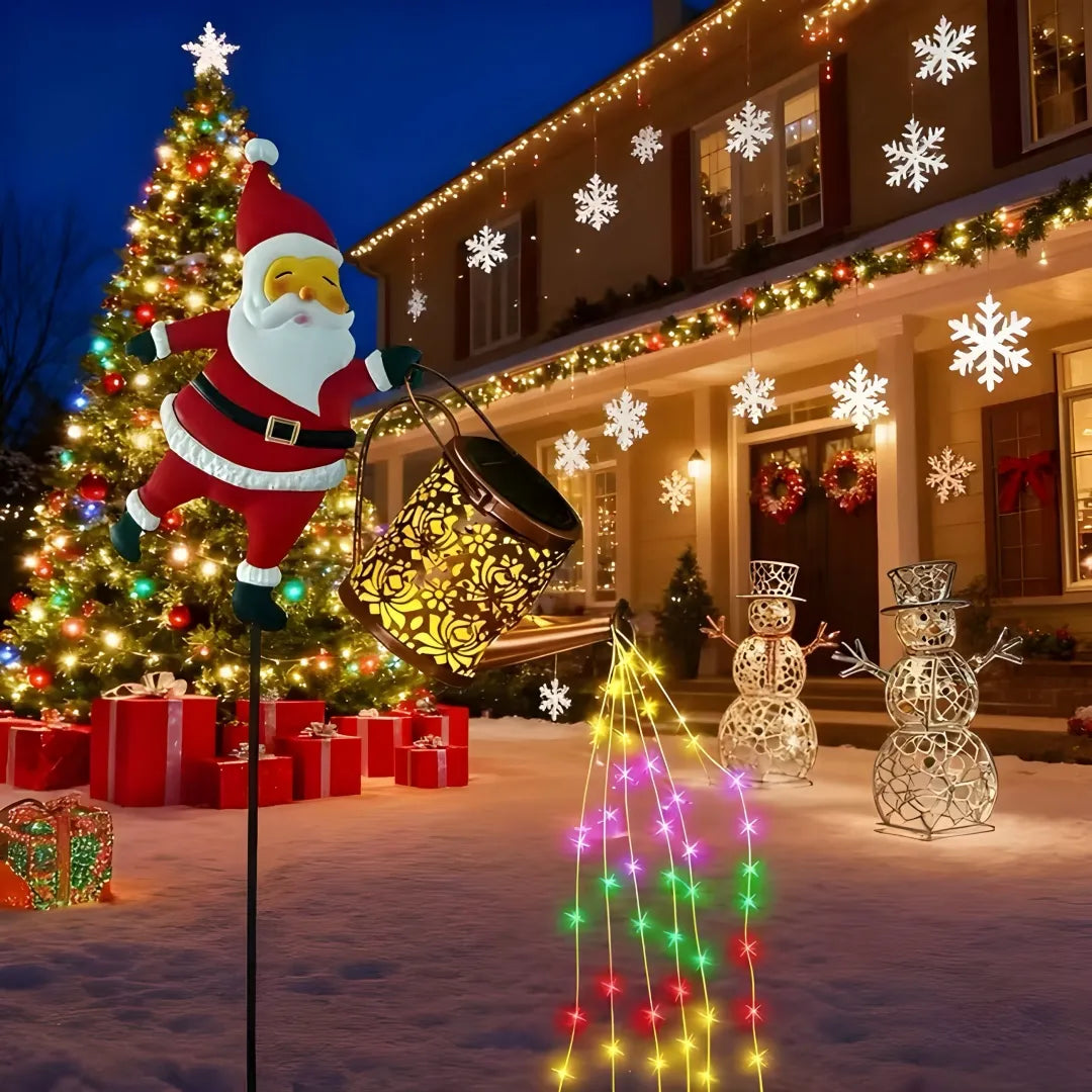 Energy efficient Santa solar light pouring colorful LED lights in snowy yard with Christmas tree and gifts.