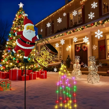 Energy efficient Santa solar light pouring colorful LED lights in snowy yard with Christmas tree and gifts.