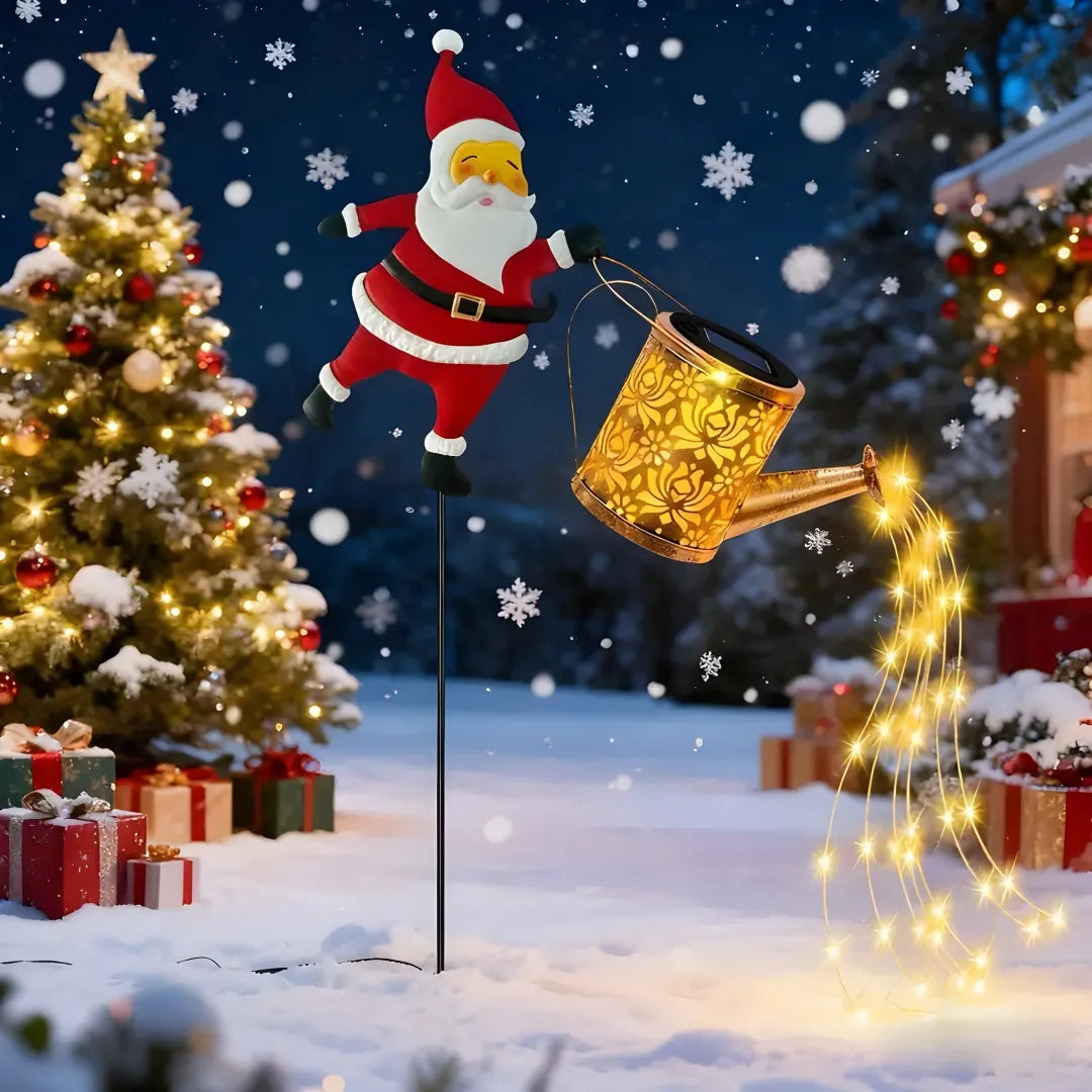 Santa solar garden light pours golden LED lights in snowy scene with Christmas tree. 