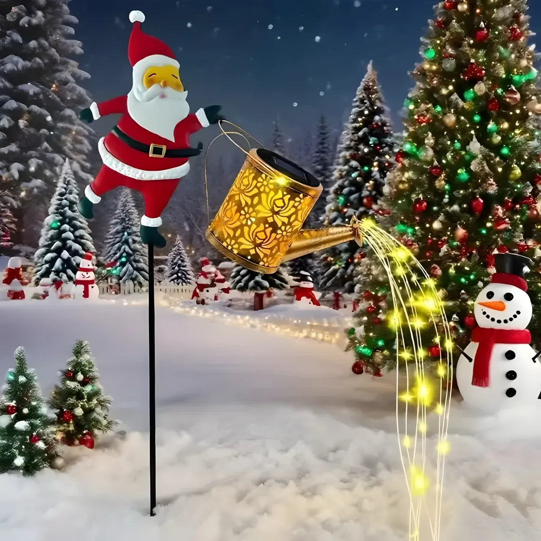Decorative solar light shaped like a watering can with Santa Claus, surrounded by Christmas trees and snowmen.