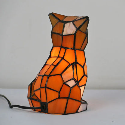 Tiffany-style stained glass cat lamp with amber and cream geometric panels, creating warm illumination for modern home decor.