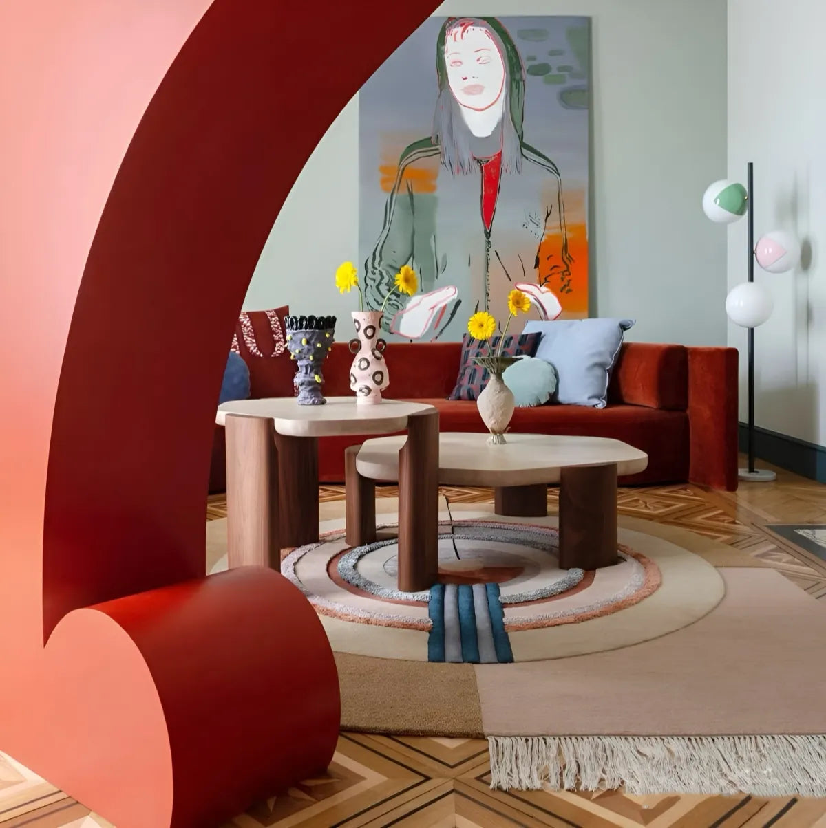 Modern living room with red sofa, round coffee table, and abstract painting on wall