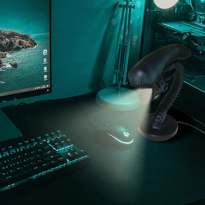 Desk setup with computer monitor, keyboard, mouse, and lamp in a dark room.