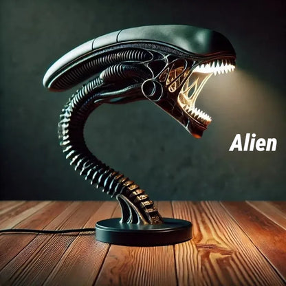 Xenomorph alien desk lamp with glowing open mouth and segmented neck. Dark sci-fi decor placed on wooden surface, perfect for collectors and gaming setups.