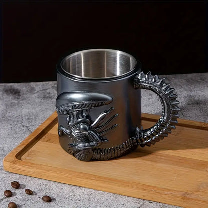 Metallic mug with alien design handle on a wooden board